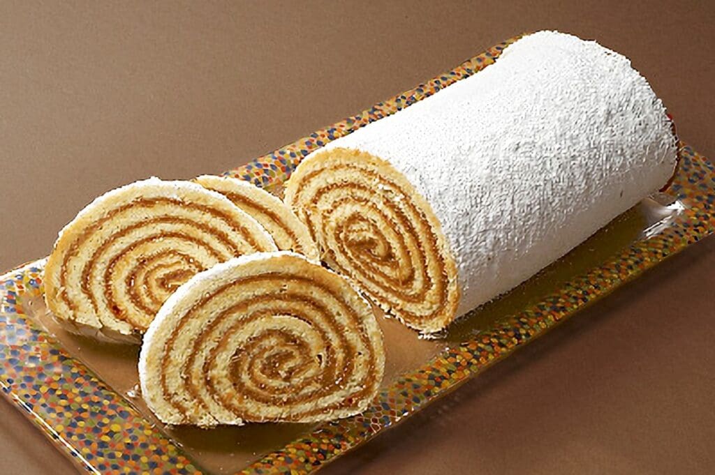 Traditional Argentine pionono sponge roll filled with dulce de leche
